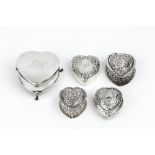 A COLLECTION OF FOUR LATE VICTORIAN SILVER HEART SHAPED TRINKET BOXES, repoussé decorated with