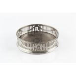 A GEORGE III SILVER BOTTLE COASTER, with beaded border, pierced and engraved with laurel swags,