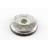 AN EDWARDIAN SILVER MOUNTED ANEROID BAROMETER, embossed with stylised scrolling foliage and having