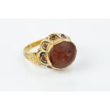 AN ENAMEL AND HARDSTONE INTAGLIO RING, the 19th century fluted setting decorated with scalloped red,