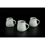 Edmund de Waal (b.1964) Three mugs light blue celadon glaze impressed potter's seals tallest 6.5cm