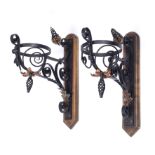 Arts & Crafts A pair of wall brackets painted cast iron and copper with later wooden brackets 45cm