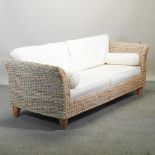 A woven three seater sofa, with loose cushions,