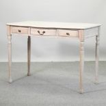 A Victorian style limed side table, containing three drawers, on turned legs,