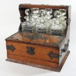 A Victorian oak combination tantalus and games box, containing three cut glass decanters,