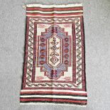 A Turkish woollen rug with geometric designs on a cream ground,