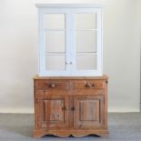 A pine cabinet with a white painted glazed top,