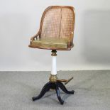 A cane revolving bar stool, on a metal base,