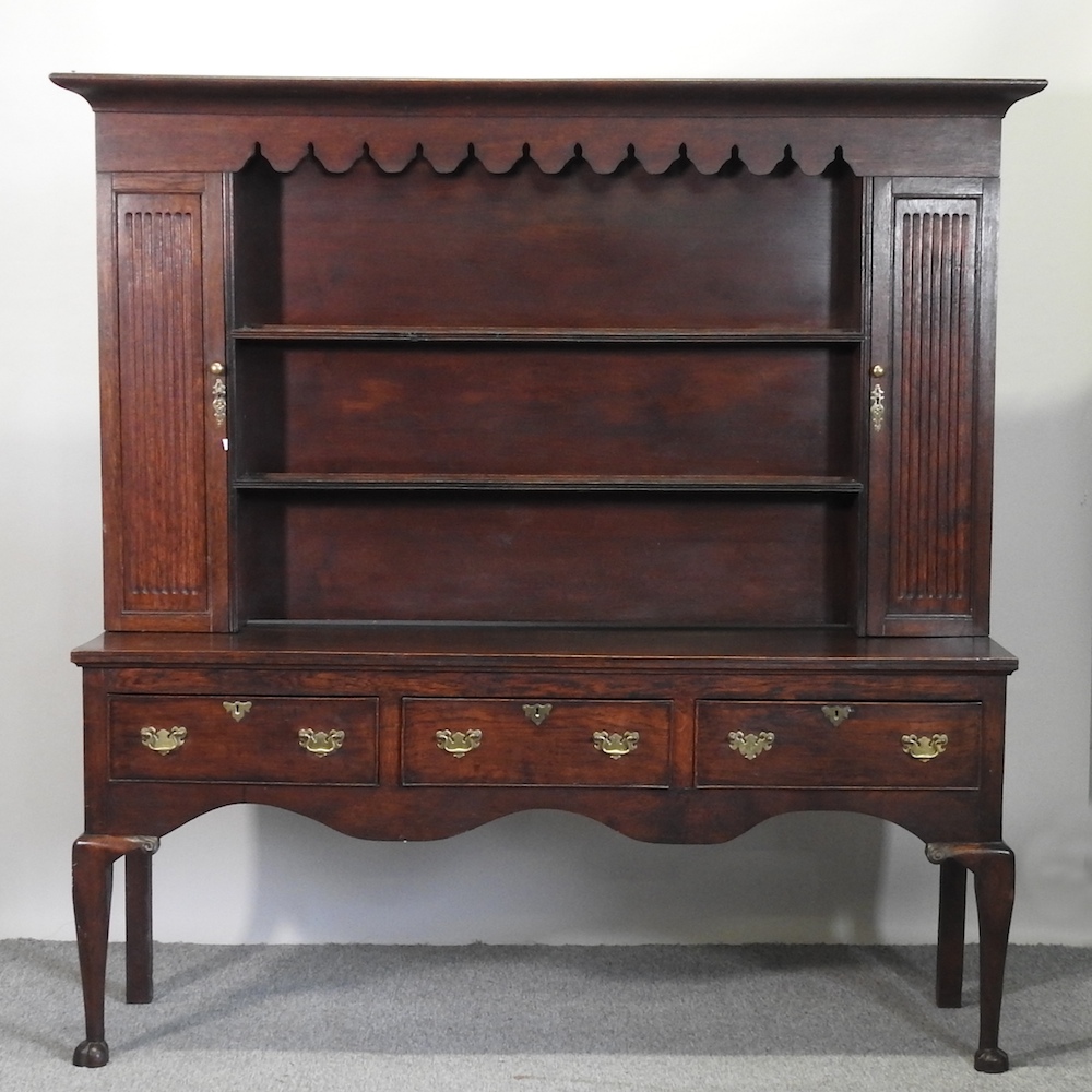 An early 20th century oak dresser, on cabriole legs,