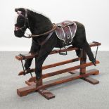 A child's rocking horse, on a wooden stand,