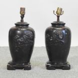 A pair of Chinese bronze table lamps, each decorated in relief with Chinese dogs,