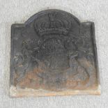 A cast iron fire back, with relief decoration,