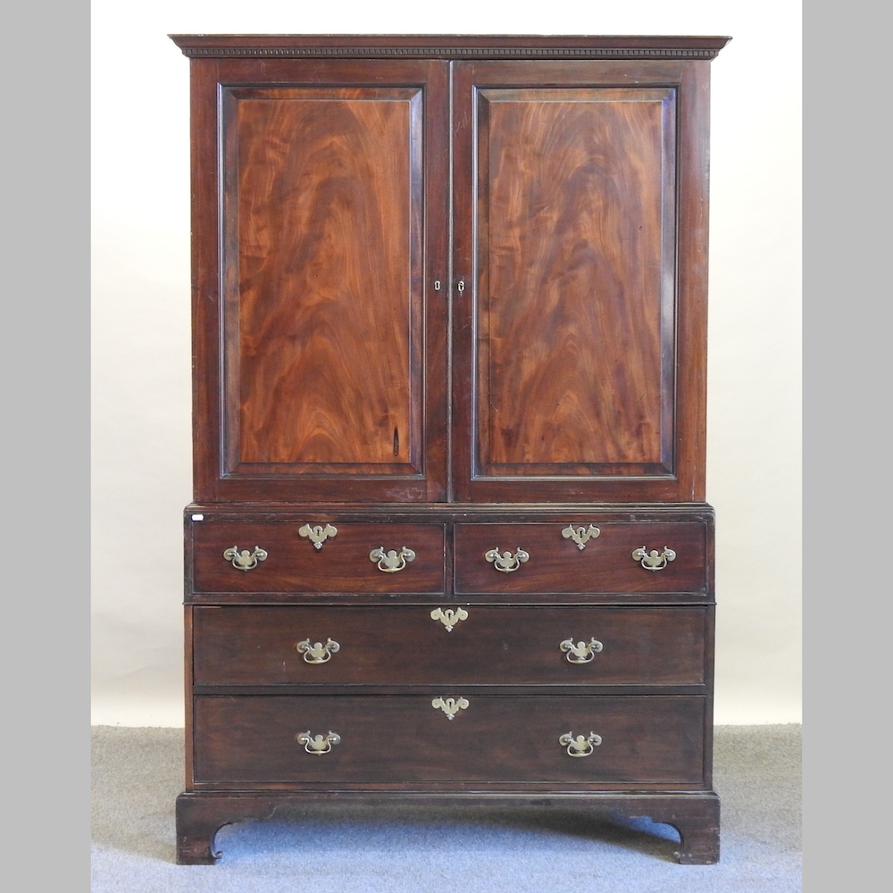 A George III mahogany linen press, with a dentil moulded cornice,