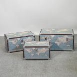 A set of three graduated trunks, each printed with a map,