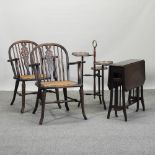 A pair of wheel back arm chairs, together a mahogany sutherland table,