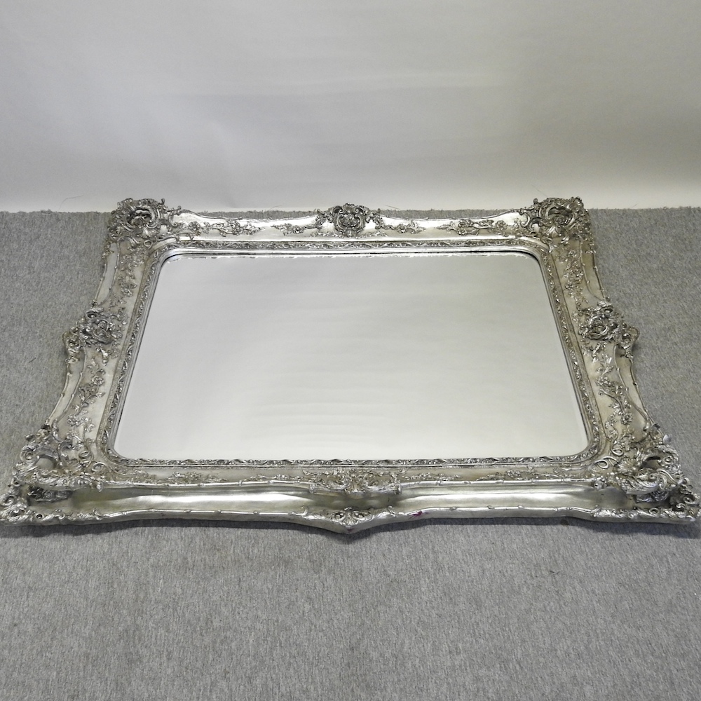 A large silver painted wall mirror,