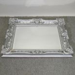 An ornate silver painted wall mirror,