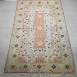 A woollen rug, with geometric design, and multiple borders, on a beige ground,
