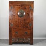 A Chinese elm wedding cabinet, enclosed by panelled doors,