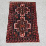 A Turkish woollen rug, with two central medallions, on a red ground,