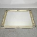 A large ornate silver painted framed wall mirror,