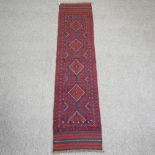 A Turkish woollen runner, with five central diamonds, on a red ground,
