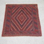 A Turkish rug, with diamond pattern, on a red ground,