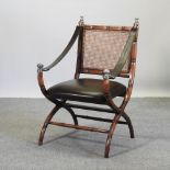 A brown leather upholstered x-frame chair,