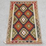 A kelim rug, with diamond pattern, on a beige ground,