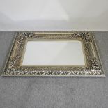 A large ornate silver painted wall mirror,