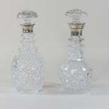 A cut glass decanter with a silver collar, together with another similar,