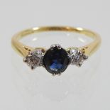 An 18 carat gold and platinum set, sapphire and diamond three stone ring,