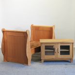 A cherrywood child's bed, together with a light oak cabinet,