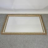 A gilt a green painted framed wall mirror,