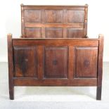 An 18th century style carved oak double bedstead, with a slatted wooden base,