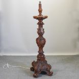 An ornate Italian style carved oak standard lamp, with a revolving top,