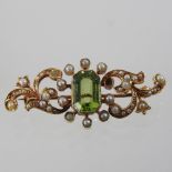 An early 20th century unmarked peridot and pearl brooch, of scrolled design,