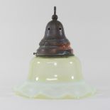 An early 20th century green vaseline green glass light shade, of frilled shape, with a brass mount,