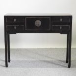 A Chinese black lacquered side table, containing an arrangement of short drawers,