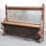 A 19th century Gothic style carved settle, with a mirrored back,