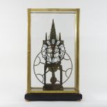 A modern brass skeleton clock, in a glazed display case,