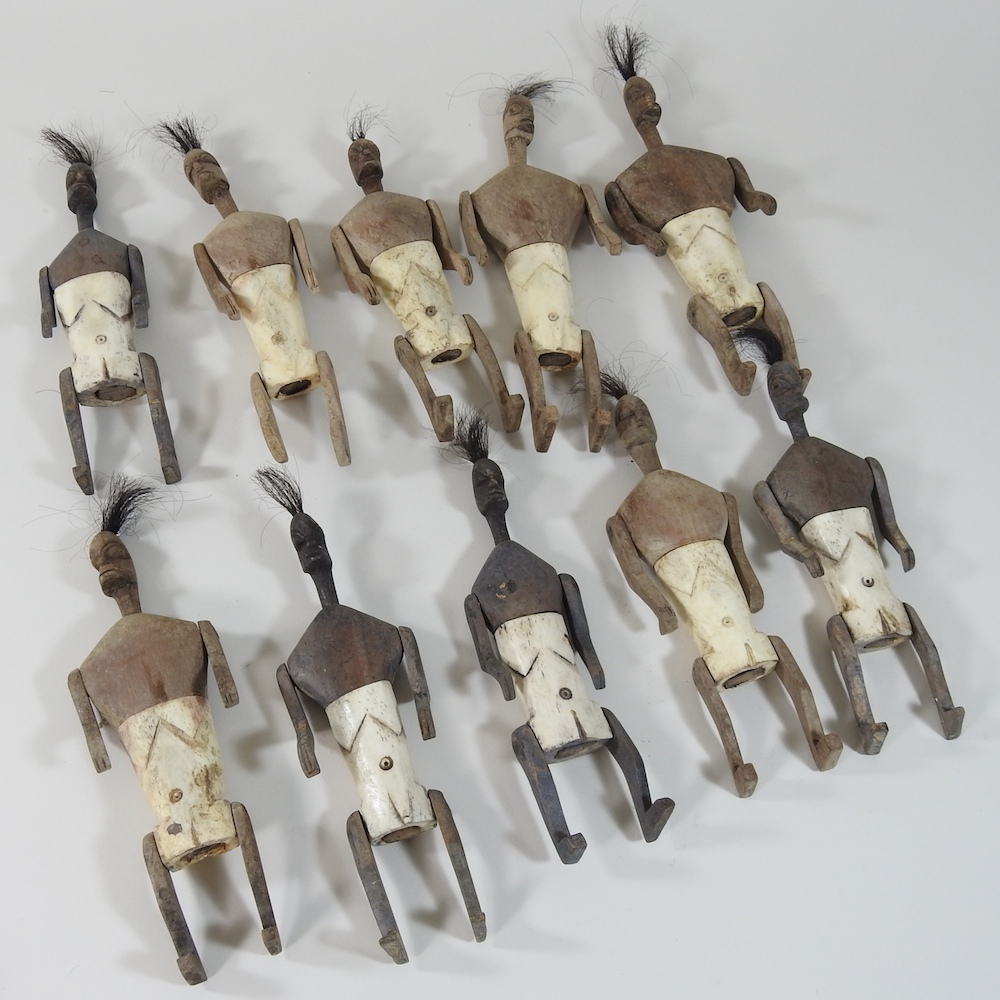 A collection of Indonesian Timor isle wooden and bone tribal dolls, with articulated limbs,