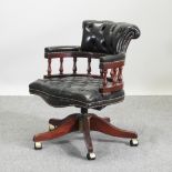 A green leather upholstered revolving desk chair, together with an Edwardian occasional table,