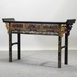 An oriental black lacquered and gilt painted altar table, with pierced decoration,
