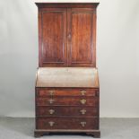 An 18th century oak bureau cabinet, on bracket feet,