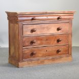 A stained pine chest of drawers, with a cushion drawer,