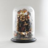 A Victorian glass dome, containing artificial flowers, on an ebonised base,