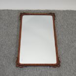 An early 20th century walnut framed wall mirror,