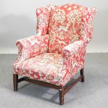 A 19th century floral and animal print upholstered wing back armchair