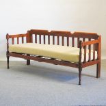 An early 20th century stained pine day bed, with a loose cushion,